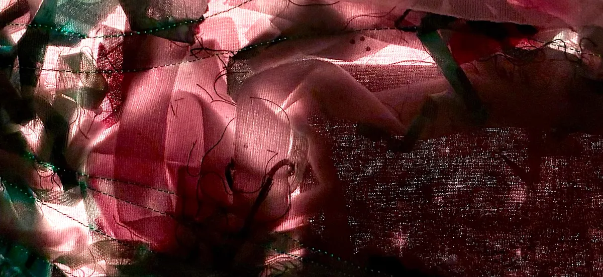 Detail of illuminated textile map in shades of dark pink