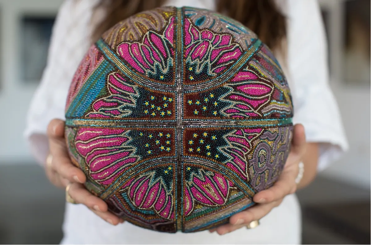 hands hold a beaded basketball