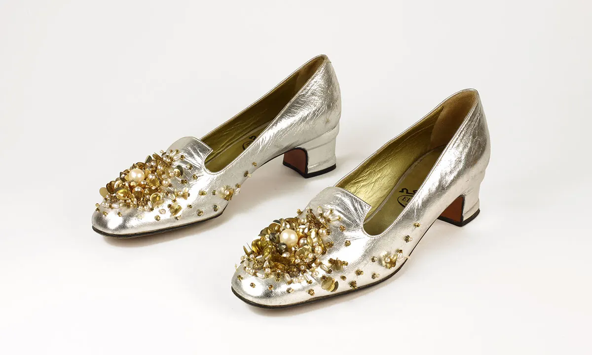 A pair of silver pump heels with beaded vamps