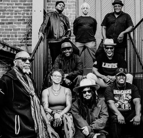 The band sits on an apartment stoop together.