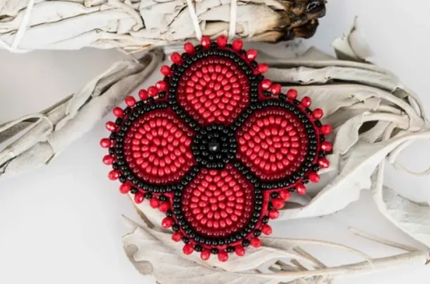 An Indigenous beaded red and black poppy