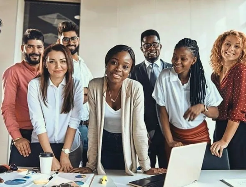 A group of young professionals lean over a table.