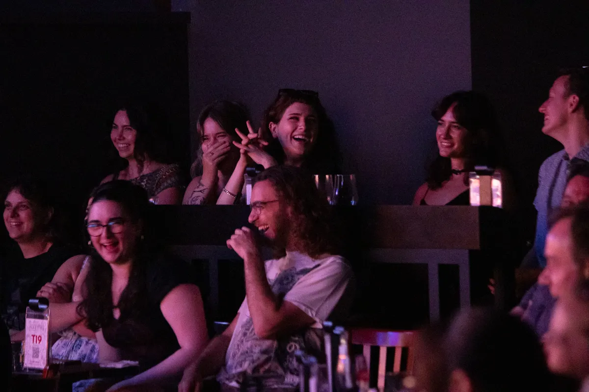 Audience laughing hard, seated in rising tiered style at The Second City