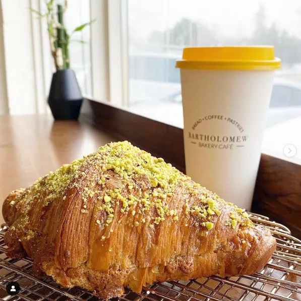 A pistachio-covered pastry and a Bartholomew Bakery coffee, from the operator’s earlier pairing article. Current stock may differ.